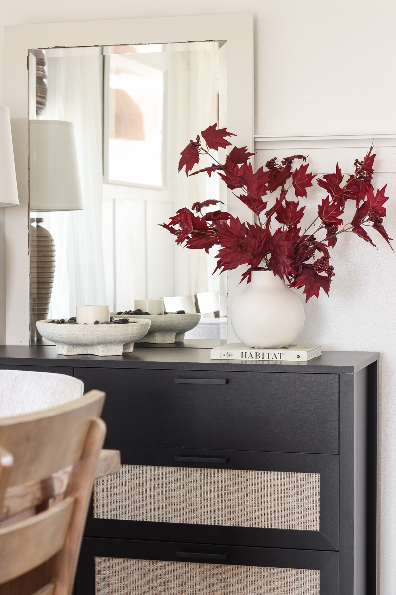 Home blogger and interior decorator Liz Fourez shares a beautiful fall vignette in her dining room featuring deep red fall branches and a new furniture find that has a high-end look without the high-end price